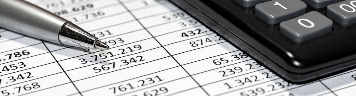 Ein Kugelschreiber und ein Taschenrechner liegen auf einer Tabelle mit Zahlen.